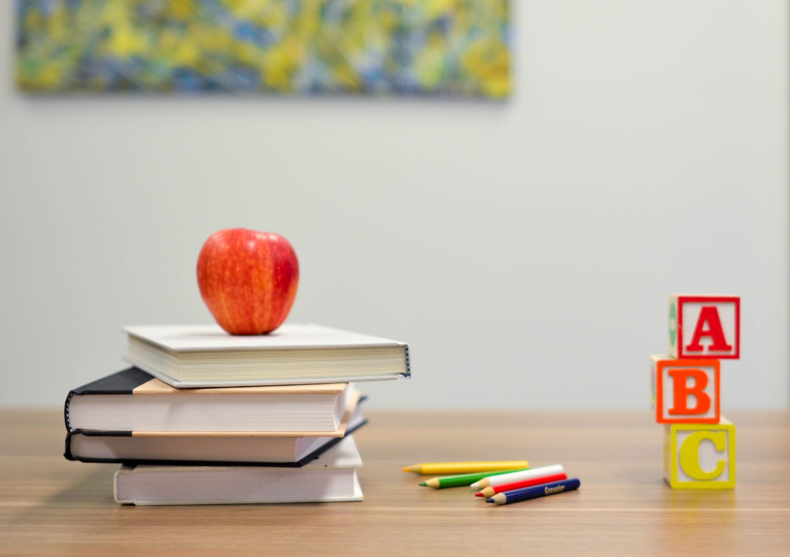 Books, apple, coloured pencils and ABC wooden blocks