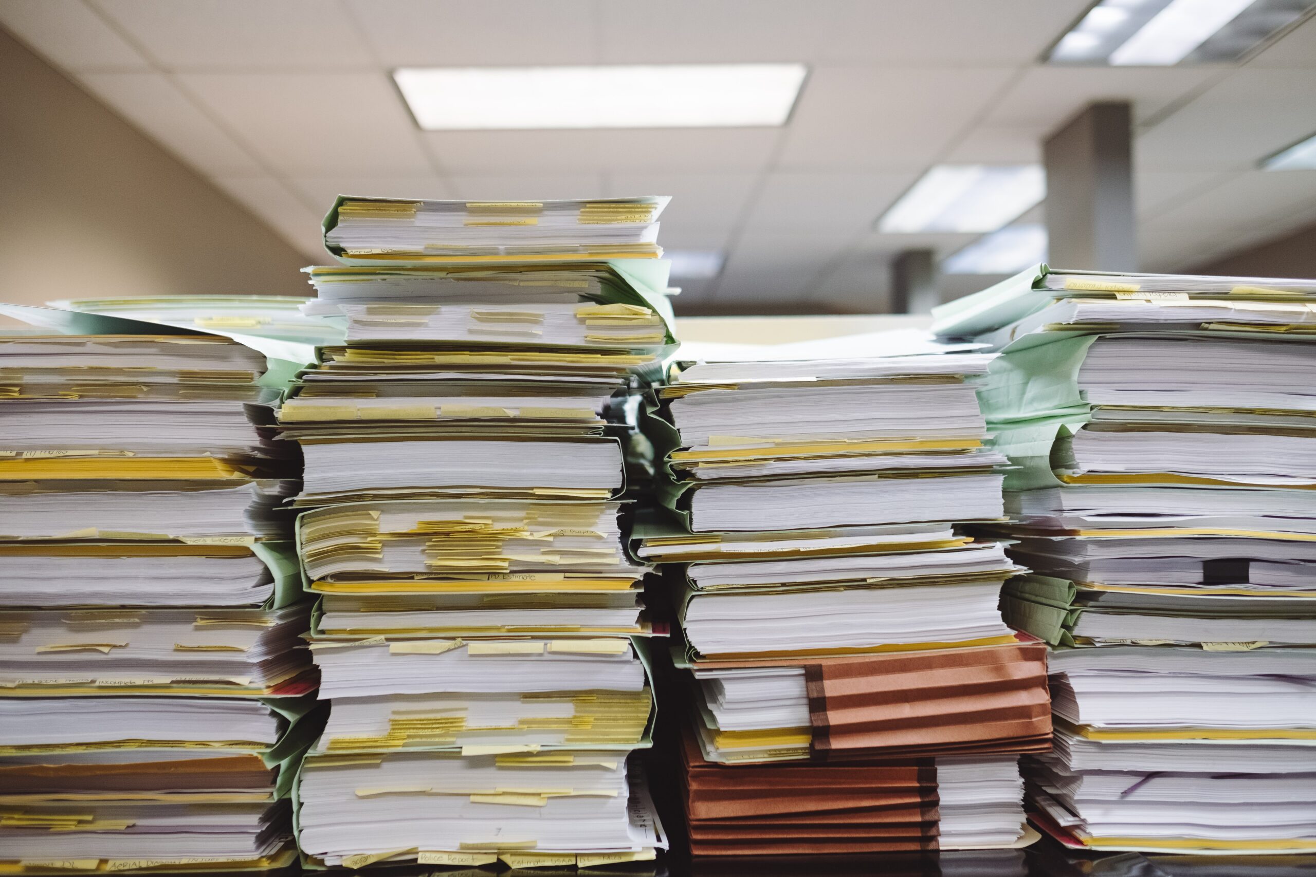 Large stacks of books and files on a table.