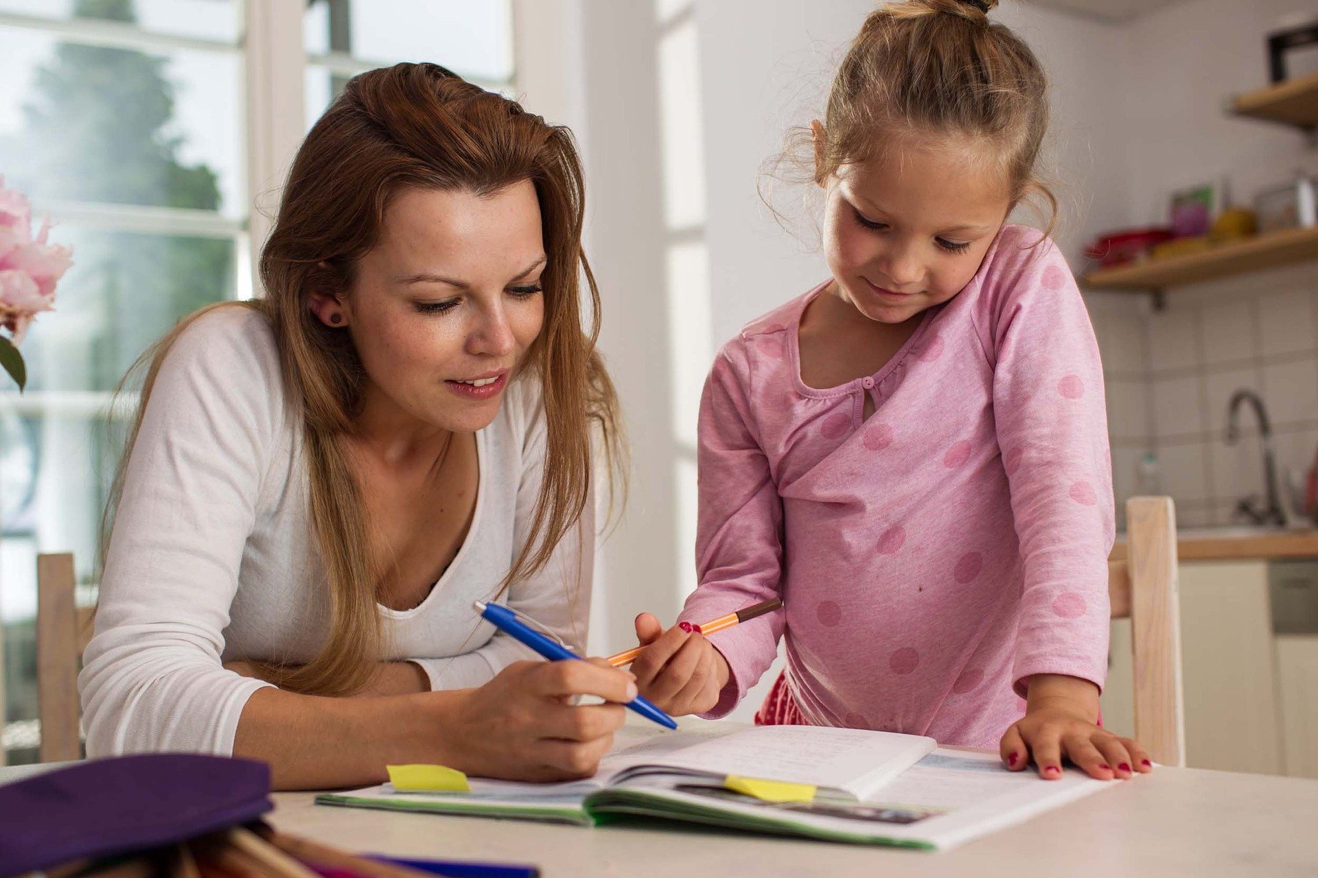 Happy mother and child reading a book together.